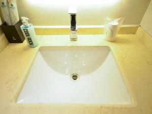 a bathroom sink with a faucet and two bottles of soap at City Comfort Inn Yichang Shenxiwan Three Gorges Highway Intersection in Yichang