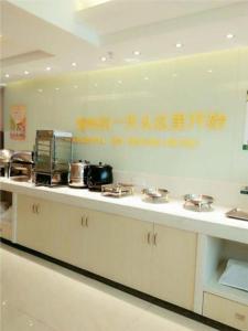 a kitchen with a counter with pots and pans at City Comfort Inn Ganzhou Railway Station in Ganzhou