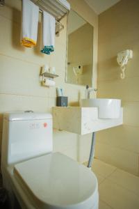 a bathroom with a white toilet and a sink at City Comfort Inn Ganzhou Railway Station in Ganzhou