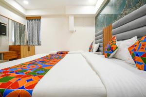 a bedroom with a large bed with a colorful bedspread at FabHotel Amantra in Ahmedabad