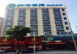 um grande edifício com uma placa em cima em City Comfort Inn Huanggang Huangmei Passenger Station em Huangmei