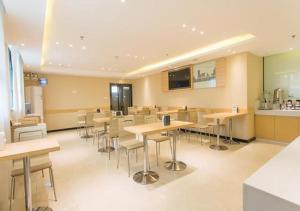 a cafeteria with tables and chairs in a room at City Comfort Inn Nanning Chaoyang Square Theater Metro Station in Nanning