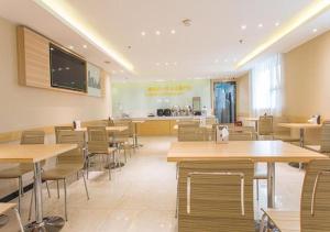 a restaurant with wooden tables and chairs and a counter at City Comfort Inn Nanning Chaoyang Square Theater Metro Station in Nanning