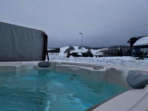 uma banheira de hidromassagem com neve no chão em Villa Tähkä - 11 henkilölle - HimosYkkösen alue - 116m2 em Jämsä