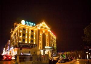 een verlicht gebouw met 's nachts een bord bij City Comfort Inn Huangshi Yangxin Mingyuewan Park in Yangxin