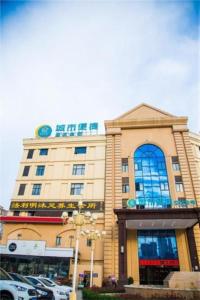 een groot gebouw met auto's geparkeerd voor het bij City Comfort Inn Huangshi Yangxin Mingyuewan Park in Yangxin