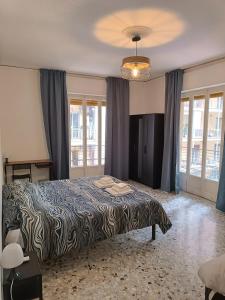 a bedroom with a large bed in a room with windows at B&B Napoli Fuorigrotta in Naples