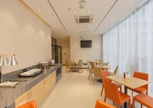 a dining room with tables and chairs and a kitchen at City Comfort Inn Liuzhou Gubu Street Ma'anshan Park in Liuzhou