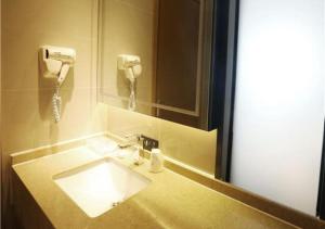 City Comfort Inn Liuzhou Gubu Street Ma'anshan Park في ليوشو: حمام مع حوض وهاتف على الحائط