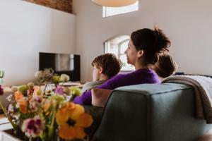 een vrouw en een kind zittend op een bank bij HEI15 in Sint Geertruid