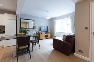 a kitchen and a living room with a table and a couch at Central - Free Parking - Family House in Harrogate