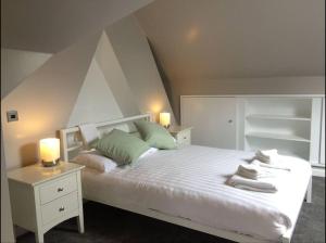 a bedroom with a white bed with green pillows at Central - Free Parking - Family House in Harrogate