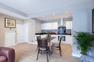 a kitchen and living room with a table and chairs at Central - Free Parking - Family House in Harrogate