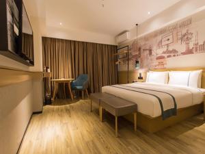 ein Hotelzimmer mit einem Bett und einem Schreibtisch in der Unterkunft City Comfort Inn Baise High Speed Railway Station in Baise