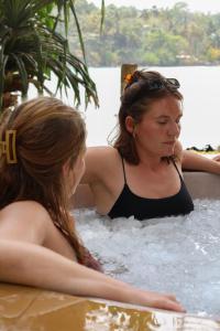 two women sitting in a bathtub in the water at Surf Home Stay Hiriketiya in Hiriketiya