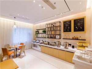 kuchnia z blatem, stołem i krzesłami w obiekcie City Comfort Inn Qingdao Taidong Business District w mieście Fushansuo