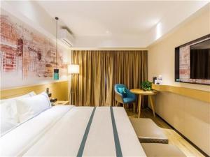 Pokój hotelowy z dużym łóżkiem i biurkiem w obiekcie City Comfort Inn Qingdao Taidong Business District w mieście Fushansuo