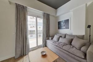 ein Wohnzimmer mit einem Sofa und einem großen Fenster in der Unterkunft Viola Comfort Suite in Athen