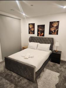 ein großes Bett in einem Schlafzimmer mit zwei Bildern an der Wand in der Unterkunft Jgb 2-Bed Apartment in London in London