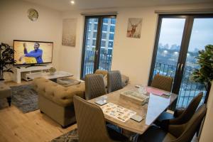 a living room with a table and chairs and windows at Jgb 2-Bed Apartment in London in London