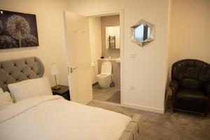 a bedroom with a bed and a chair and a mirror at Jgb 2-Bed Apartment in London in London