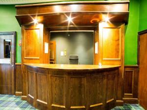 un bar en una habitación con una pared verde en OYO Hotel Majestic en Lockerbie