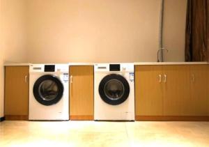 dwie pralki siedzące obok siebie w pokoju w obiekcie City Comfort Inn Ezhou Hengda w mieście Ezhou