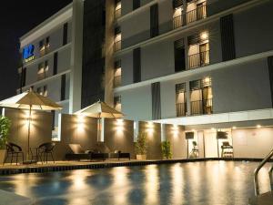 Ban Chak Samo的住宿－B2 Amata Nakorn Premier Hotel，一座游泳池,在晚上在建筑物前
