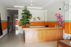 un mostrador de recepción con un árbol de Navidad en la pared en Hotel Meigah en Tanjung Pandan