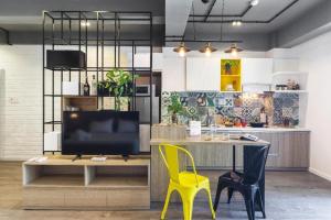 a kitchen with a desk and a yellow chair at OPOX Nha Trang in Nha Trang