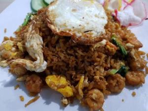 un plato de comida con arroz frito y camarones en Hotel Meigah en Tanjung Pandan