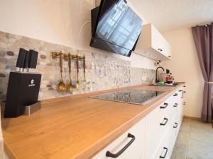 eine Küche mit einer Arbeitsplatte und einem TV an der Wand in der Unterkunft Ferienhäuschen Storchennest in Schönau am Königssee