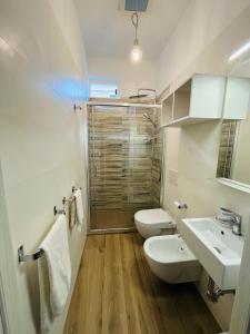 a bathroom with a toilet and a sink and a shower at La Maison in Grottammare