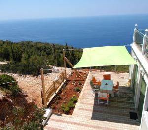 a staircase with a green umbrella on top of a house at Porto Katsiki Blu in Athani