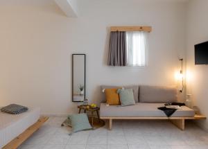 a living room with a couch and a window at Capella Town, Skiathos in Skiathos Town