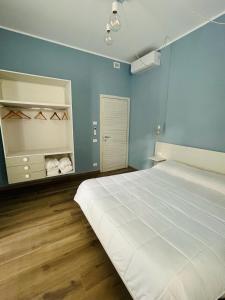 a bedroom with a large white bed and blue walls at La Maison in Grottammare