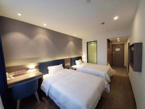 a hotel room with two beds and a television at 7 Days Premium Xianning Wenquan Shopping Center in Guanbuqiao