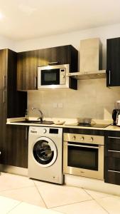a kitchen with a washing machine and a microwave at Eco Stay Luxury apt in Accra