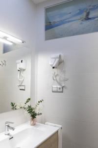 un bagno bianco con lavandino e specchio di O LAR DE ROMARÍS I - O LAR DE ROMARÍS II a Padrón
