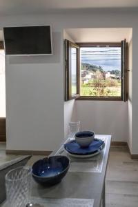 una cucina con due ciotole su un tavolo con una finestra di O LAR DE ROMARÍS I - O LAR DE ROMARÍS II a Padrón