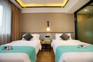 Habitación de hotel con 2 camas y mesa en Xana Lite Zhengzhou Longhai Dong Road Fenghuang Tea City, en Yanzhuang