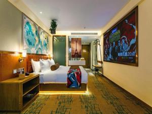 um quarto de hotel com uma cama grande e uma televisão em James Joyce Coffetel· Xianyang Renmin Road Central Square Store em Xianyang