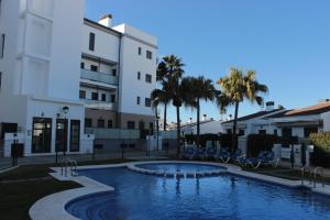 uma piscina em frente a um edifício em M515 Apartamento Las Dunas Oliva Nova em Oliva