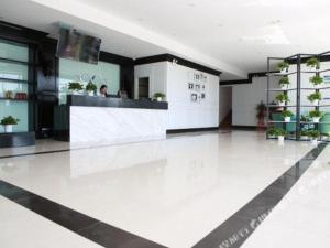 a lobby with a reception desk in a building at Xana Hotelle Ulanqab Municipal Government Wanda Plaza in Jining