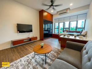 een woonkamer met een bank en een tv bij Ceylonz Leisure Suites KLCC in Kuala Lumpur