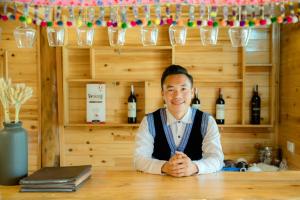 a man sitting at a table in a wine shop at Supan Ecolodge in Sa Pa