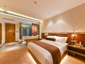 um quarto de hotel com uma cama grande e uma casa de banho em James Joyce Coffetel Shijiazhuang the Mixc Jinyuan Tower Airport Bus em Shijiazhuang