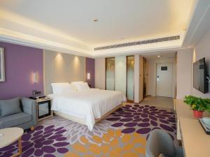sypialnia z łóżkiem, kanapą i telewizorem w obiekcie Lavande Hotels· Yueyang Linxiang Zhongfa w mieście Linxiang