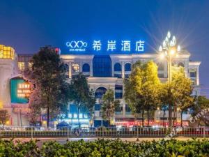 瀘州市にあるXana Hotelle Luzhou High-Speed Railway Station Trading Market Passenger Terminalの夜間の看板のある建物