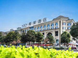 瀘州市にあるXana Hotelle Luzhou High-Speed Railway Station Trading Market Passenger Terminalの看板が立つ大きな建物